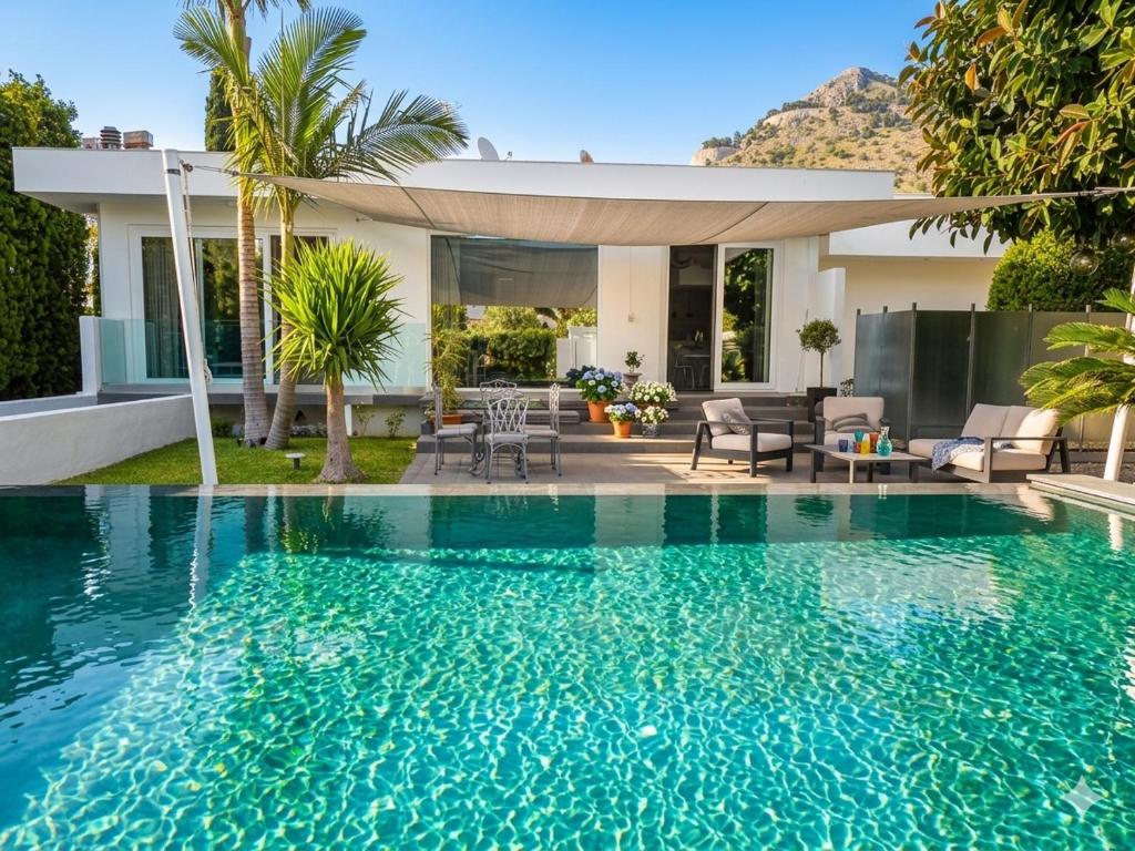 a swimming pool in front of a house at Mondello Luxury villa in Palermo