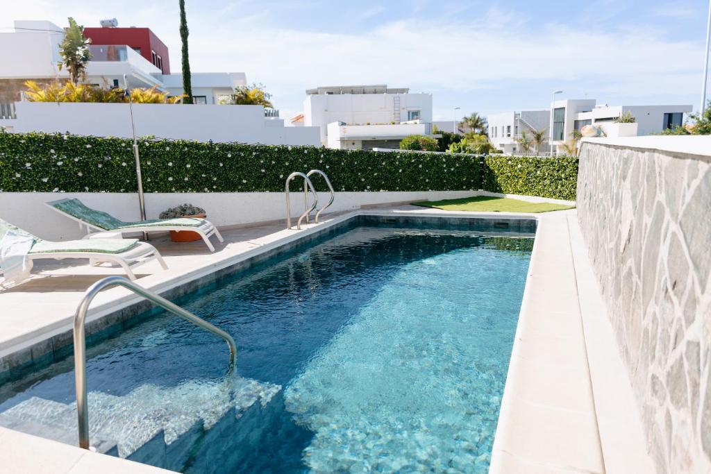a swimming pool on the side of a building at Modern 2BR Villa Private Heated Pool, BBQ, Aircon in Costa Adeje by Aqua Vista Tenerife in Callao Salvaje