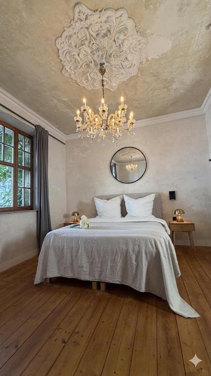 a bedroom with a large bed with a chandelier at Belle Époque in Solingen
