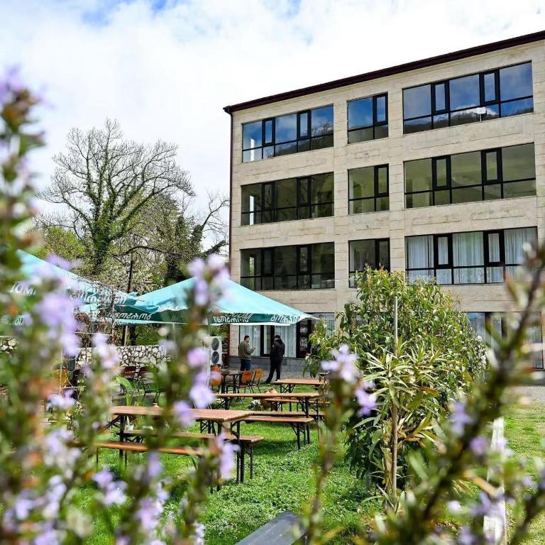 a building with picnic tables in front of a building at La Montagna in Bangveti