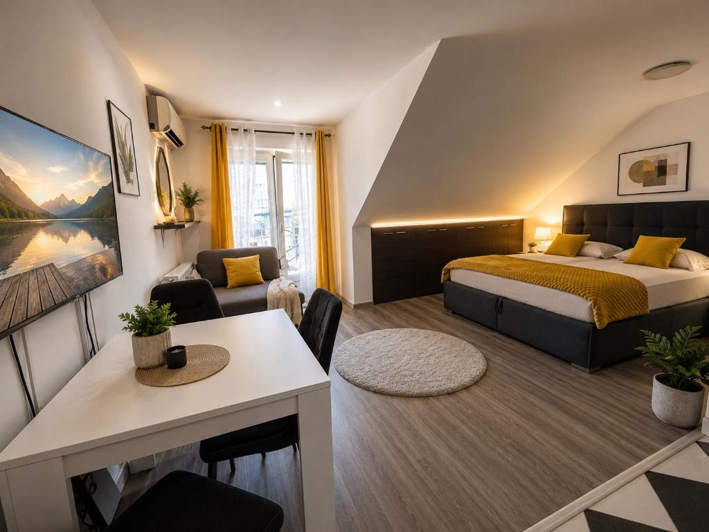 a bedroom with a bed and a living room at Iva Penthouse in Novi Sad