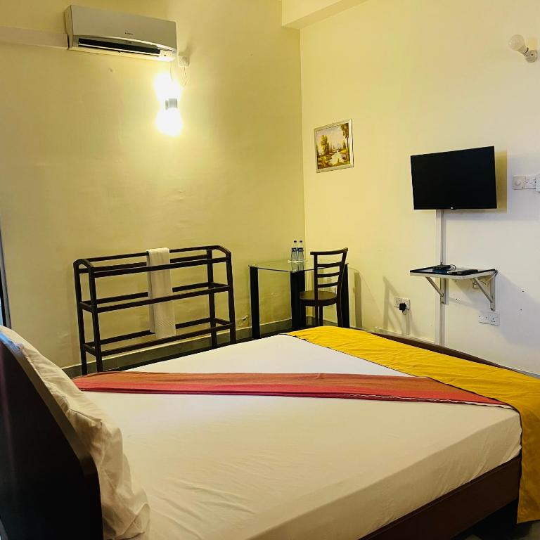 a bedroom with a bed and a flat screen tv at The Dream City Hotel in Kilinochchi