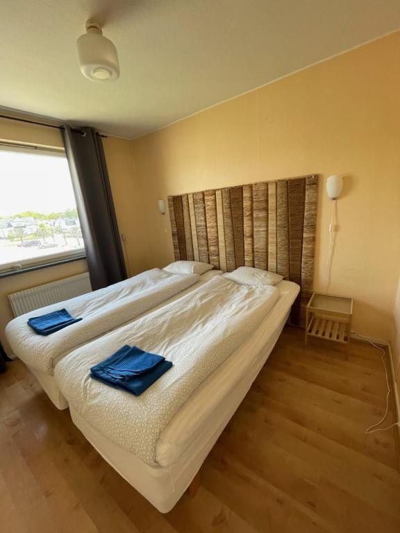 a bedroom with a large bed with two blue towels on it at Nya Dacke in Virserum