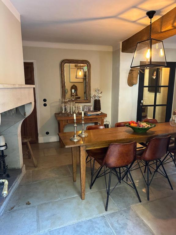 a dining room with a table and chairs and a mirror at L'aile du Chateau in Ramatuelle
