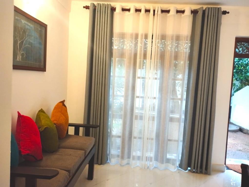 a living room with a couch and a window at Ayubo Villa in Ja-Ela