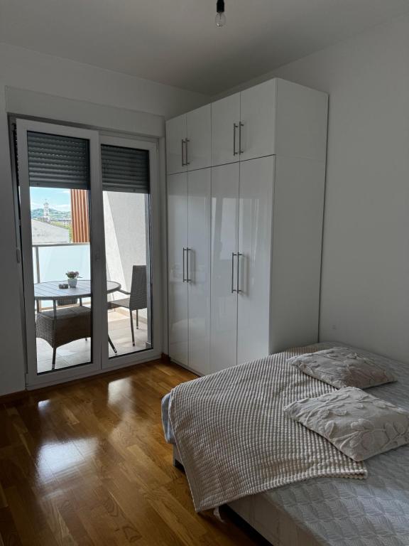 a bedroom with a bed and a dining room with a table at SIENA stan na dan Doboj in Doboj