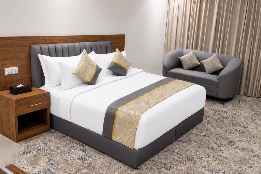ein Schlafzimmer mit einem großen Bett und einem Stuhl in der Unterkunft WS Hotel in Tabuk