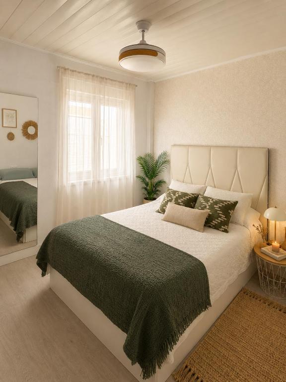 a bedroom with a large bed and a window at Abuela Maruja - Piso acogedor en Cee, perfecto para desconectar in Cee