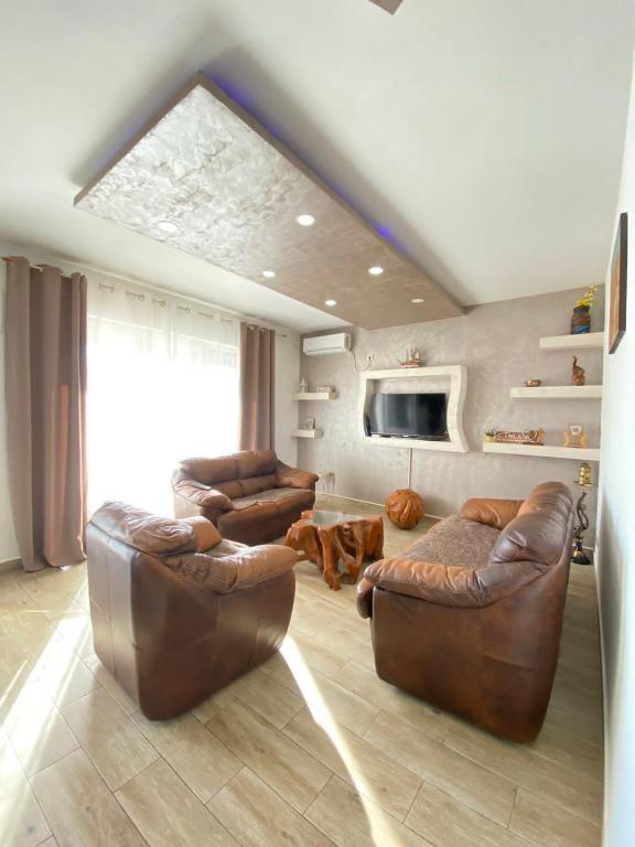 a living room with two leather chairs and a television at Batica in Radanovići