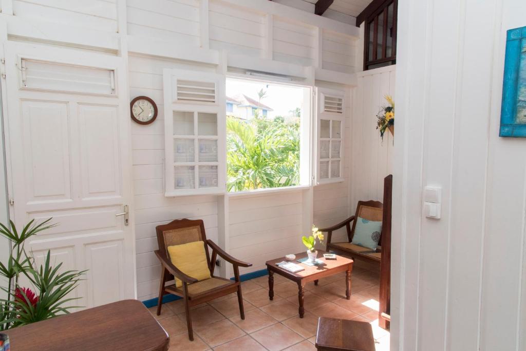 a room with chairs and a table and a window at L'escapade in Sainte-Anne