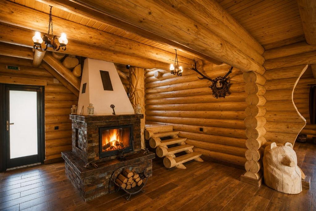 a living room with a fireplace in a log cabin at Casa Pădurarului in Câmpulung Moldovenesc