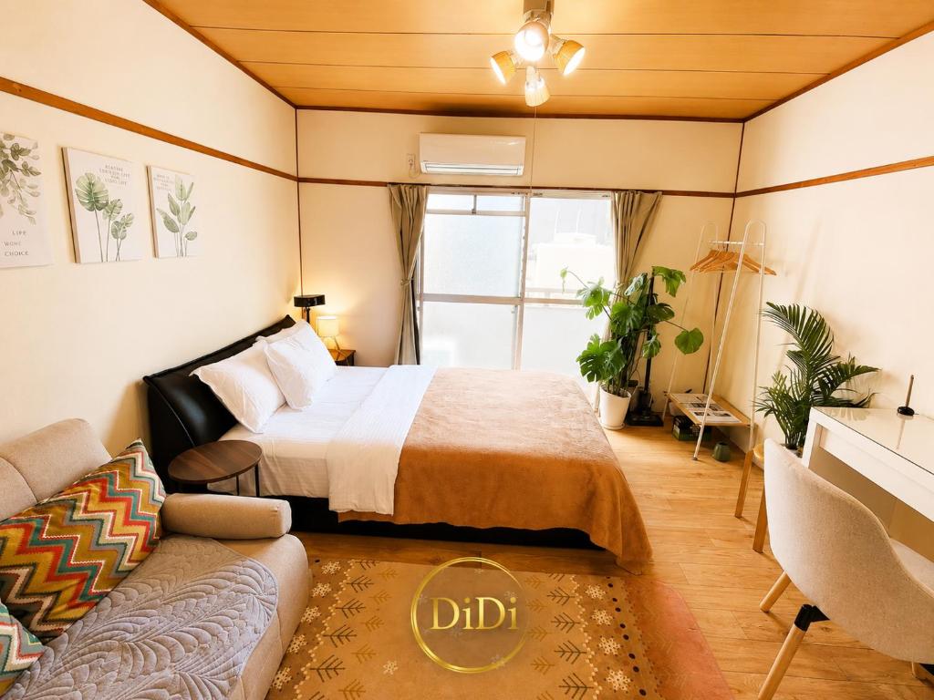 a bedroom with a bed and a couch at ゲストハウス DiDi 103 Private Apt near Park 10min from Station Netflix in Tokushima