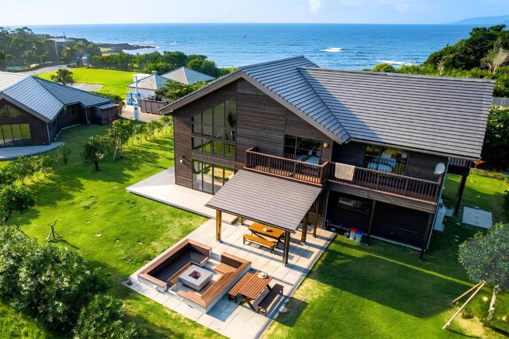 an aerial view of a house with the ocean in the background at Cairns House by SANA in Tateyama