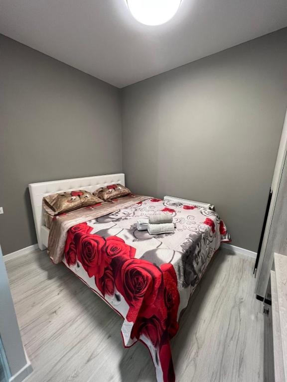 a bedroom with a bed with a red and white blanket at APARTMENT CENTRAL zm in Edineţ