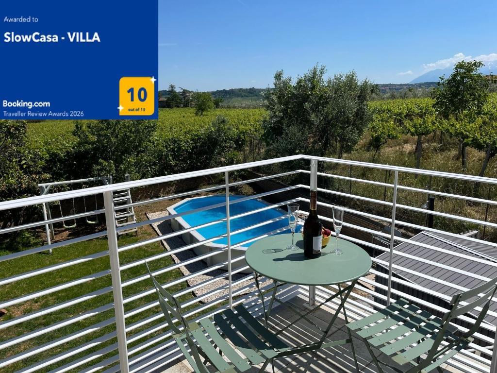 a table and chairs on a balcony with a fence at SlowCasa - VILLA Garden & Pool - Full Apartment in Torrevecchia Teatina