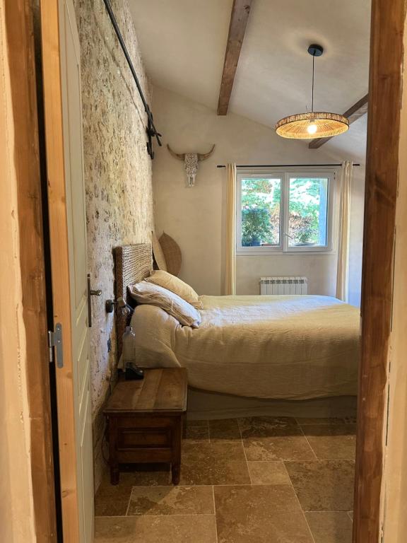 a small bedroom with a bed and a window at chambre aux moutons in Saint-Méard-de-Gurçon