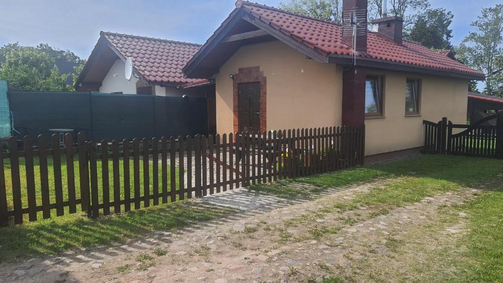 a house with a fence in front of it at Domek w Zaciszu in Cieszyno