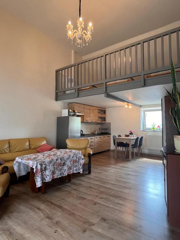 a living room with a couch and a dining room at Apartament de'Lux in Żywiec