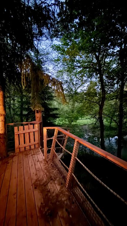 a wooden deck with a view of a body of water at Dům ve stromech nad řekou in Moravecké Pavlovice