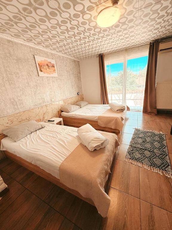 a room with three beds in a room with a ceiling at Pensiunea Johanna in Arad