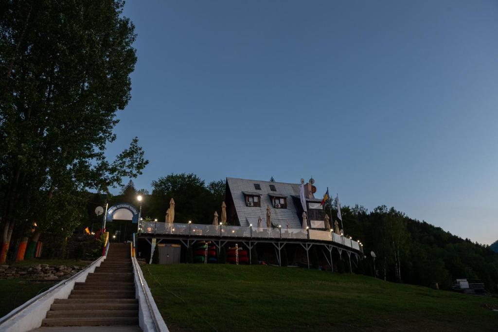 a building sitting on top of a hill with stairs at Hotel Pescarus Port Bicaz in Bicaz