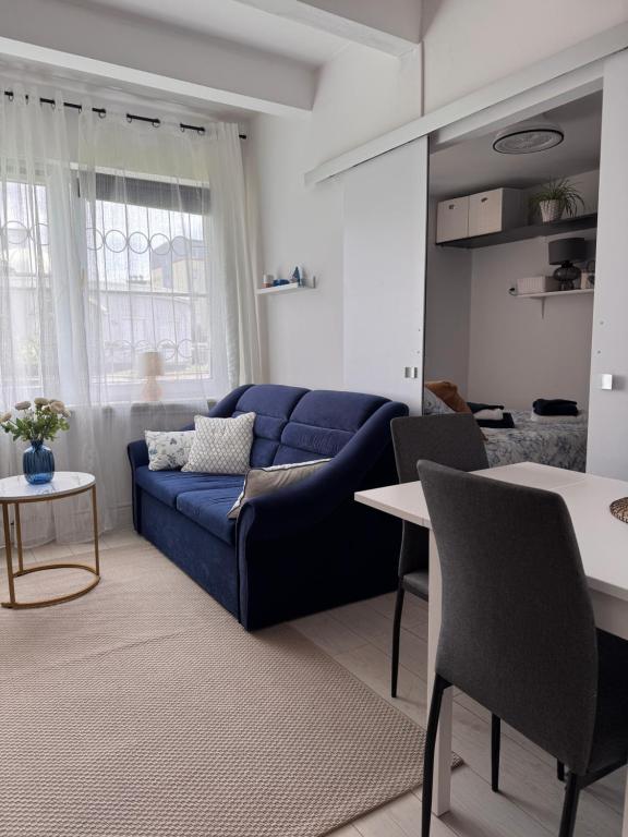 a living room with a blue couch and a table at Apartament Szafir in Gdańsk