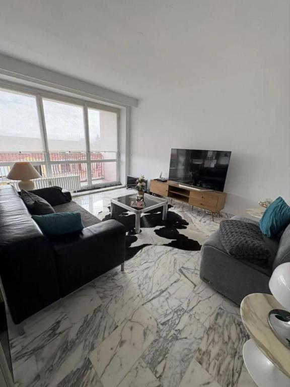 a living room with two couches and a flat screen tv at home santos in Tulle