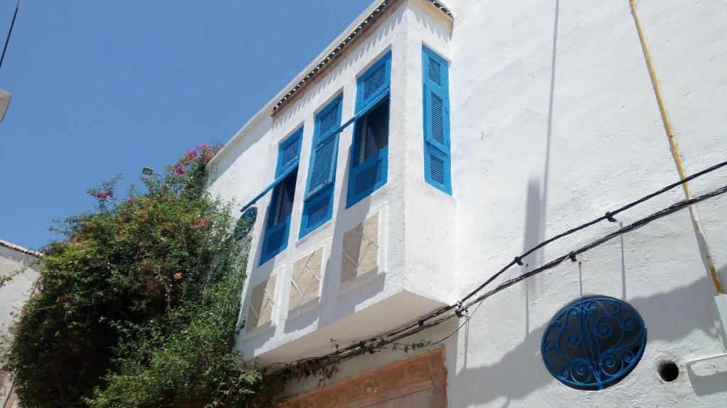 a white building with blue windows on the side of it at El Patio Courtyard House in Tunis