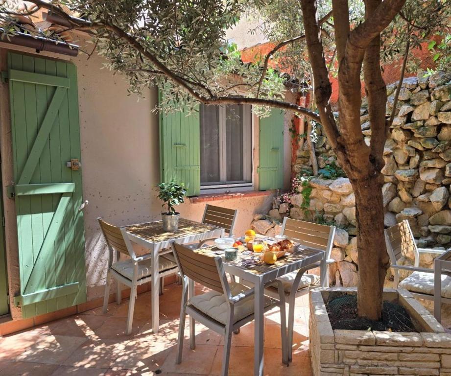 a table and chairs on a patio with a tree at Hôtel Le Colbert in Avignon