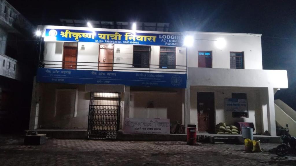a building with a blue sign on it at night at Shree krishn yatri nivas in Ellora