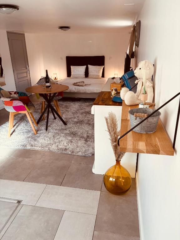 a living room with a bed and a table at Le Ptit Refuge d'Ay in Ay