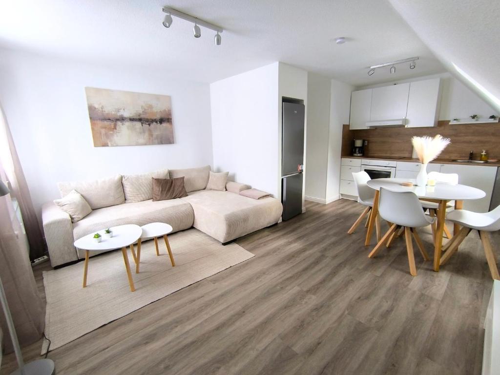 a living room with a couch and tables and a kitchen at Ferienwohnung Heide in Walsrode