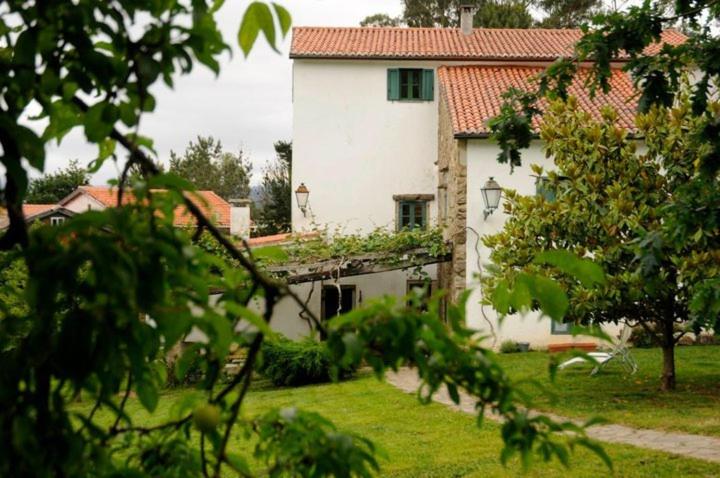 una gran casa blanca con un patio con árboles en Casa do Torno, en Noia