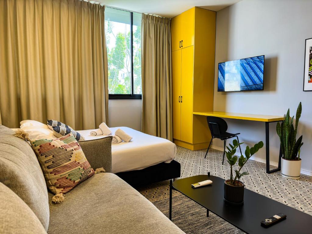 a hotel room with a couch and a bed at Levinski Market Hotel in Tel Aviv