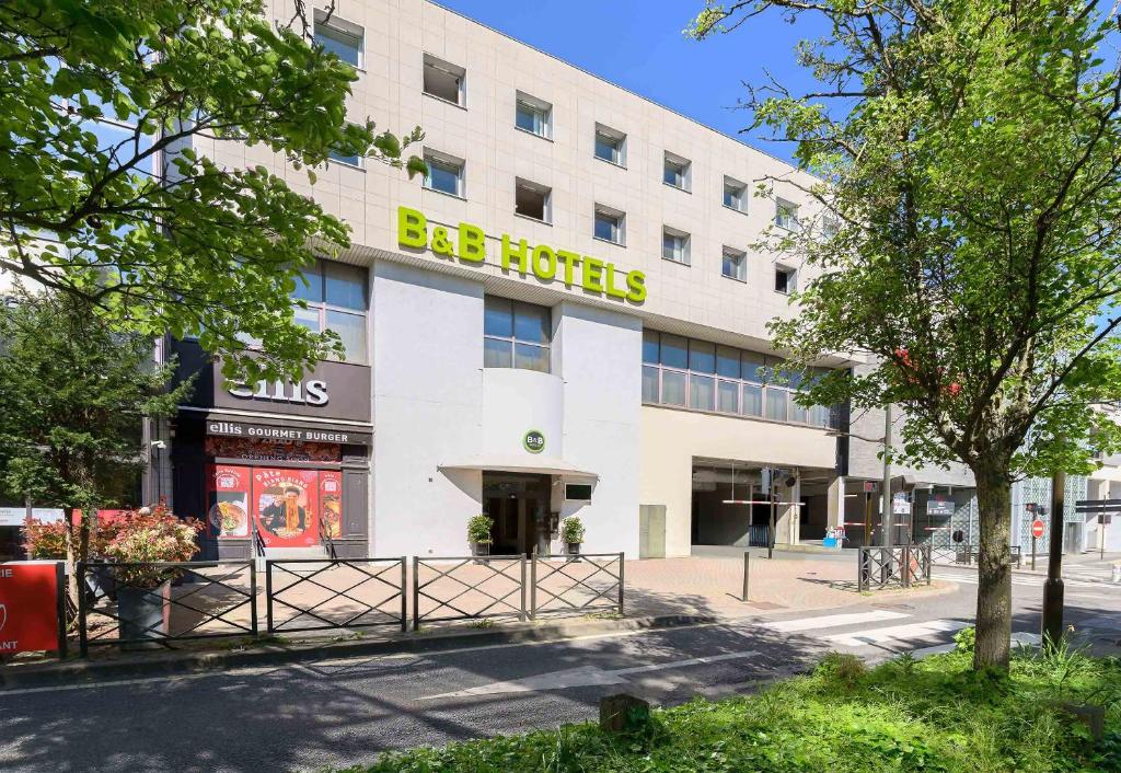 a large white building with a be hotel sign on it at B&B HOTEL Versailles Le Chesnay in Le Chesnay