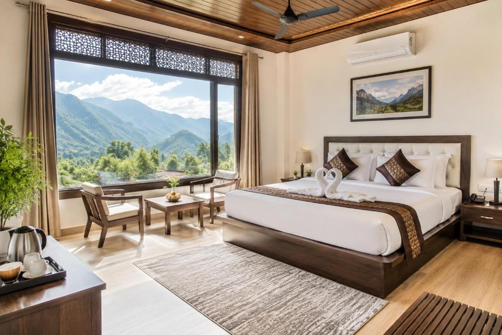 a bedroom with a bed and a large window at Skywood by Vankuteer - Pool & Mountain view Rooms in Kandāghāt