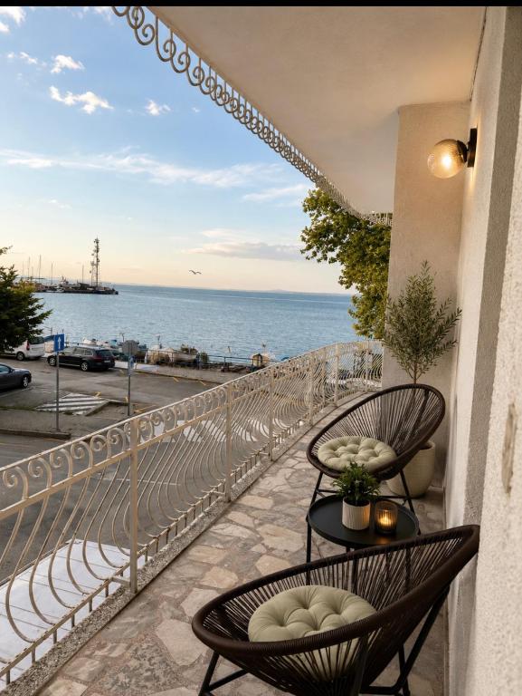 a balcony with two chairs and a view of the ocean at Апартамент Морски бряг in Pomorie