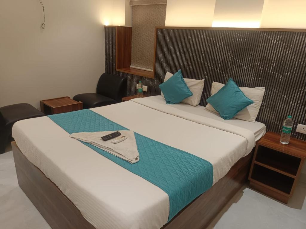 a bedroom with a large bed with blue pillows at Hotel Tals Hytek in Hyderabad