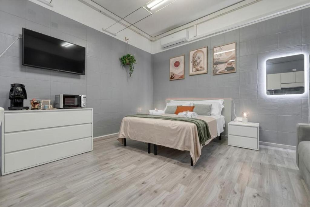 a bedroom with a bed and a flat screen tv at Flow Urban Living by DiffeRent in Ferrara