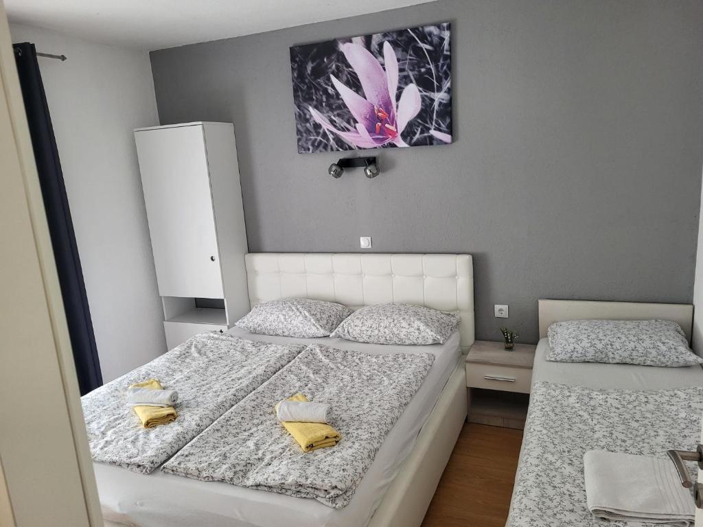 a bedroom with two beds and a painting on the wall at Apartman D&D 1 in Jajce