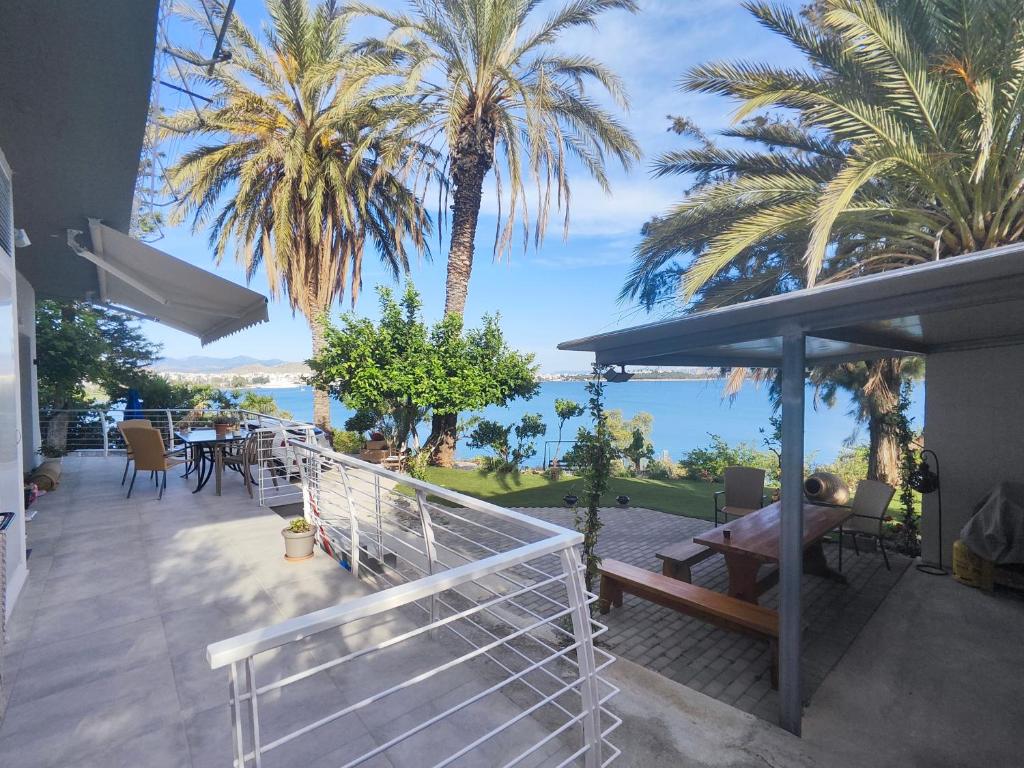 a balcony with palm trees and a view of the ocean at Anna's sea view apartment in Kánithos