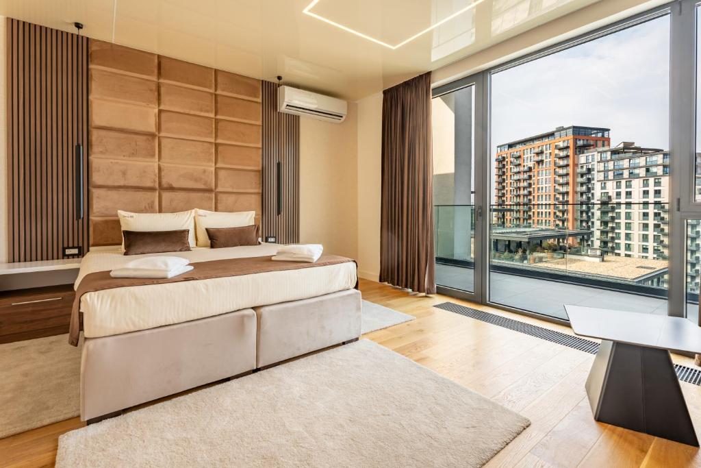 a bedroom with a bed and a large window at Hotel Eterna Hill Rooftop in Sajmište