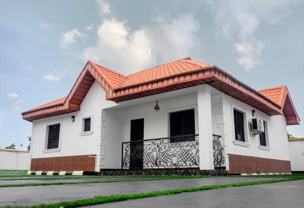a white house with a red roof at Smile Apartment in Ilishan