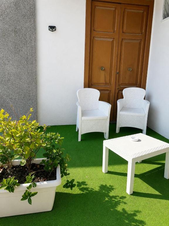 two chairs and a white table and a table and chairs at Station Comfort House in Pagani