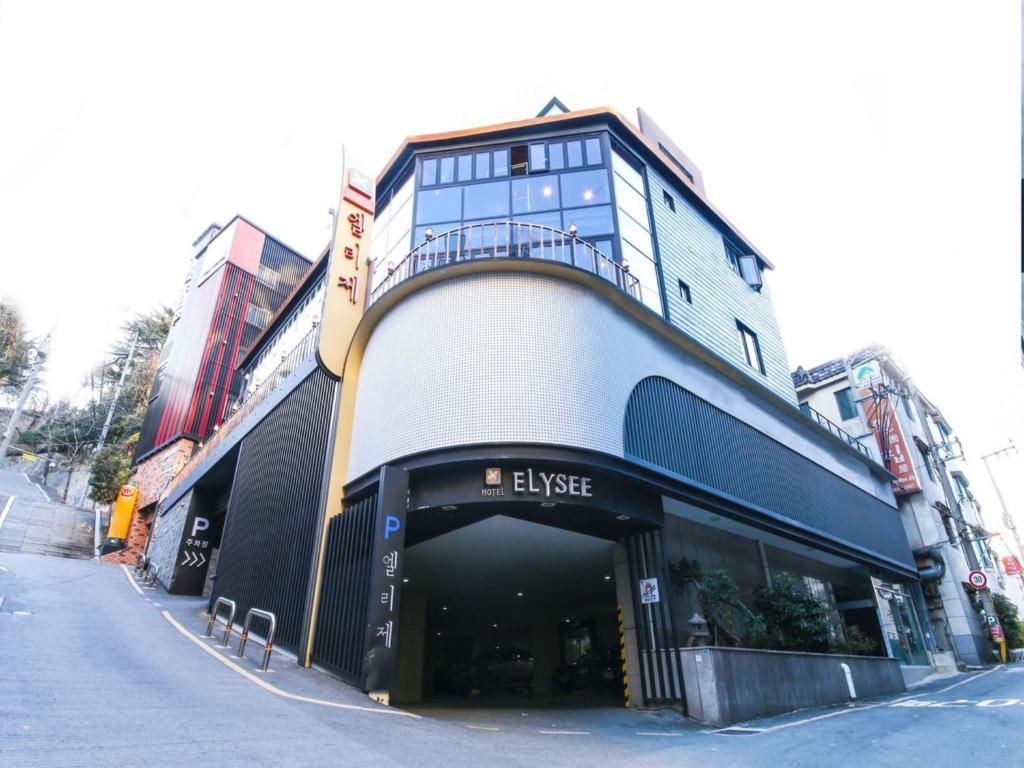 a large building with a balcony on a street at Elysee Hotel in Busan