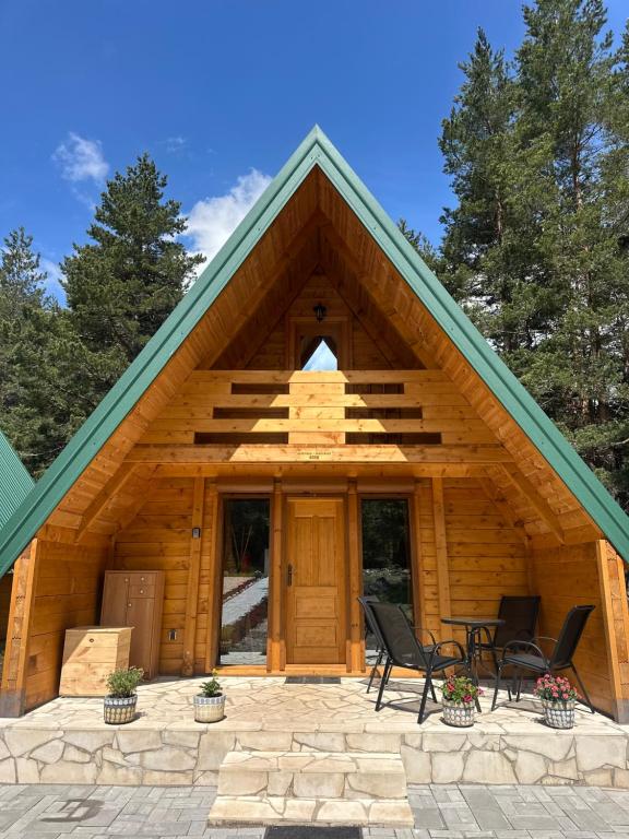 a log cabin with two chairs and a porch at Apartman Boro in Žabljak