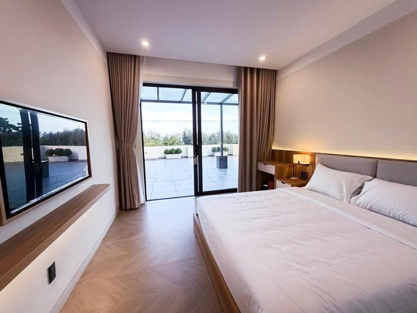 a bedroom with a large bed and a large window at Sơn Trà 668 in Sa Vi Xom