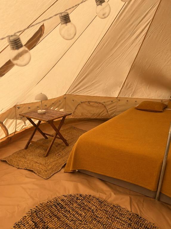 a bed and a table in a tent at Glamping teltta Venekoski in Hankasalmi