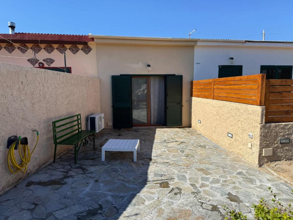 a green bench sitting in front of a house at Casa SILMAGA in La Maddalena