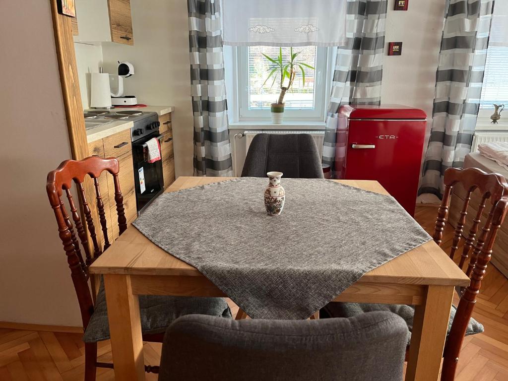 a dining room table with a vase on top of it at Apartment Lagma in Železniki